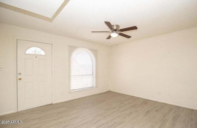 entrance foyer with a healthy amount of sunlight, a ceiling fan, and wood finished floors