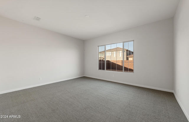 unfurnished room featuring dark carpet