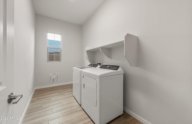 laundry area with separate washer and dryer and light hardwood / wood-style flooring