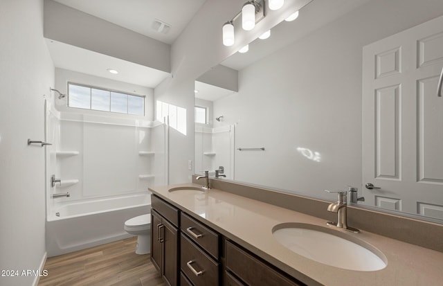 full bathroom with bathing tub / shower combination, vanity, wood-type flooring, and toilet