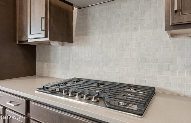 kitchen with backsplash, dark brown cabinetry, and stainless steel gas cooktop