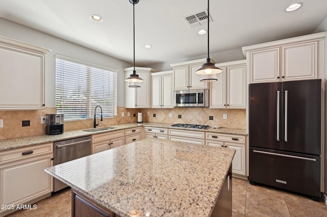 kitchen featuring tasteful backsplash, visible vents, stainless steel appliances, and a sink