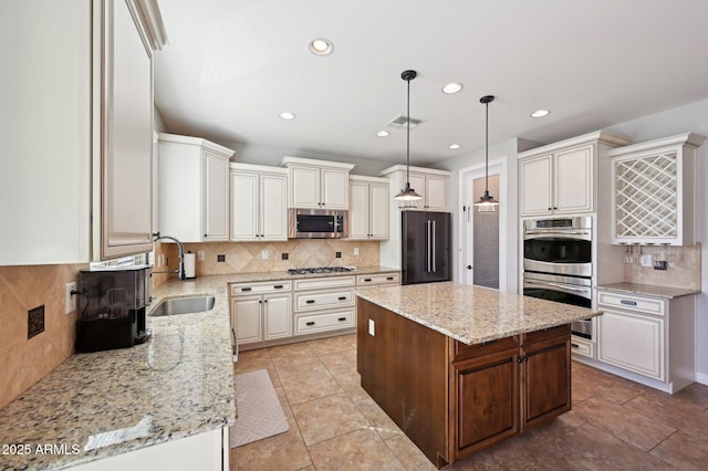 kitchen with a sink, visible vents, light stone countertops, and appliances with stainless steel finishes