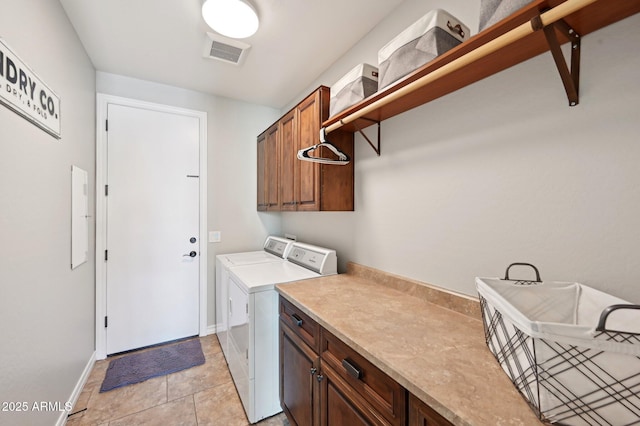 washroom with visible vents, washing machine and dryer, cabinet space, light tile patterned flooring, and baseboards