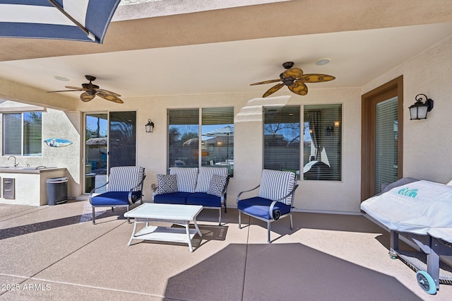 view of patio featuring a ceiling fan and a sink