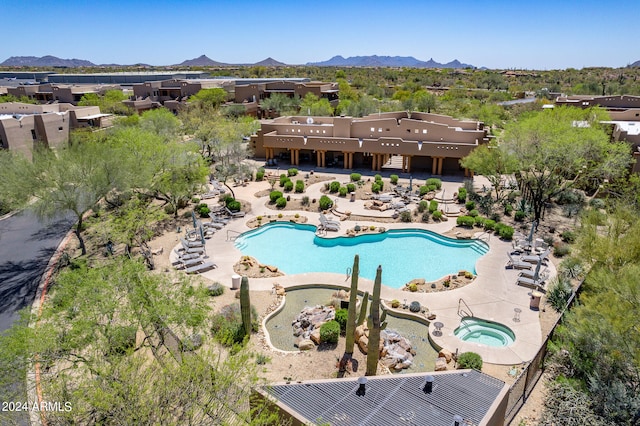 view of pool with a mountain view, a community hot tub, and a patio area