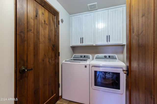 laundry room with washing machine and dryer and cabinets