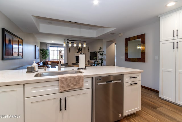 kitchen featuring sink, dishwasher, light hardwood / wood-style floors, white cabinetry, and pendant lighting