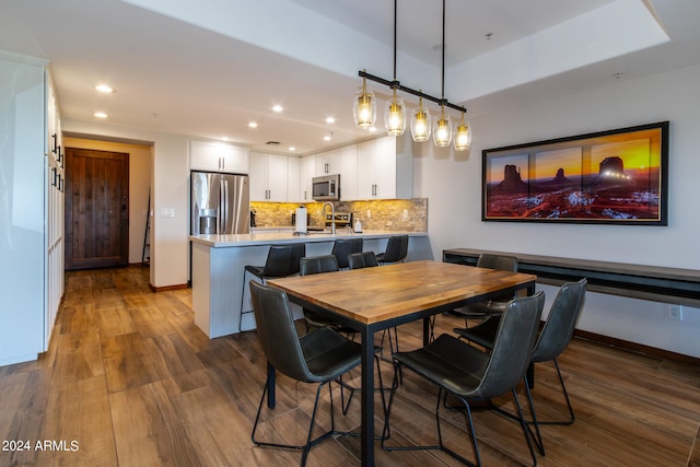 dining area featuring hardwood / wood-style floors and a tray ceiling