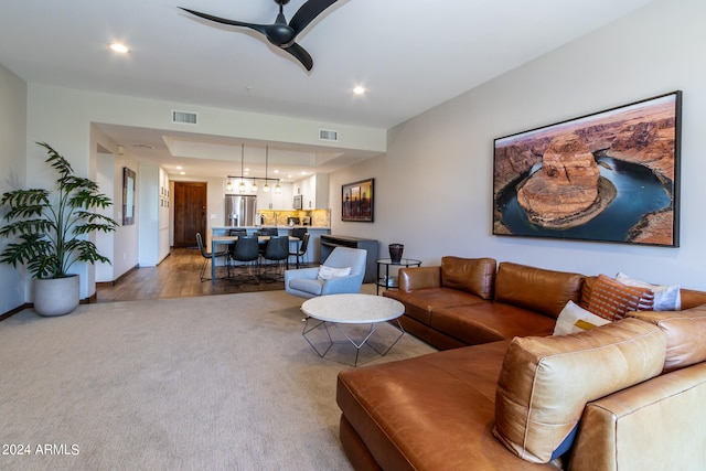 carpeted living room featuring ceiling fan