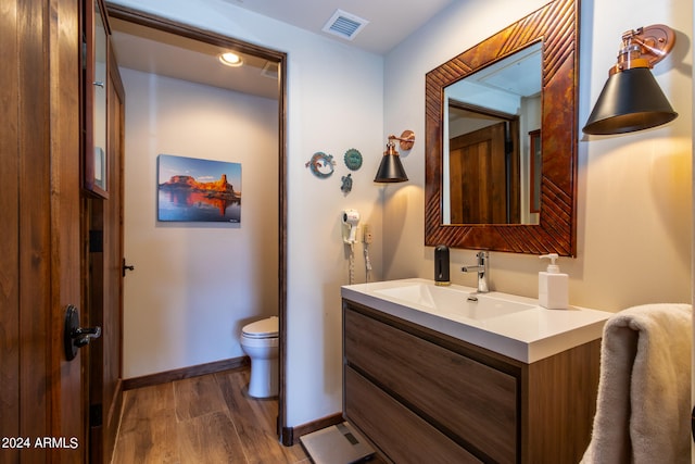 bathroom featuring hardwood / wood-style flooring, toilet, and vanity