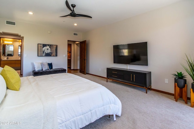 bedroom with light carpet, ceiling fan, and ensuite bath