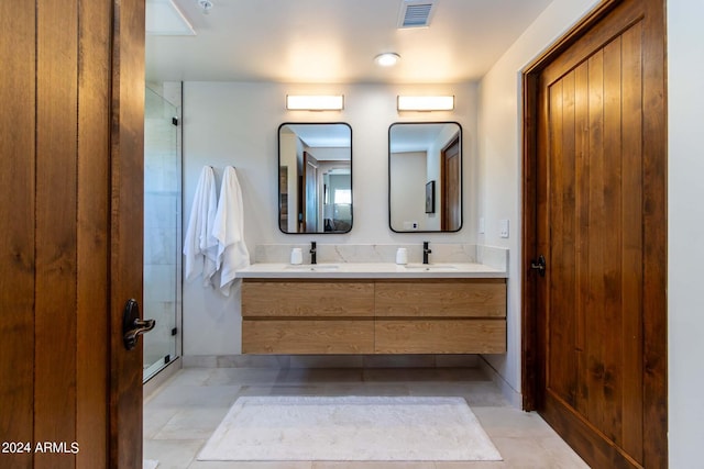 bathroom with a shower with door, tile floors, and double sink vanity