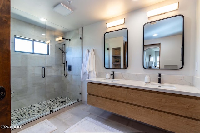 bathroom with tile flooring, dual sinks, large vanity, and walk in shower