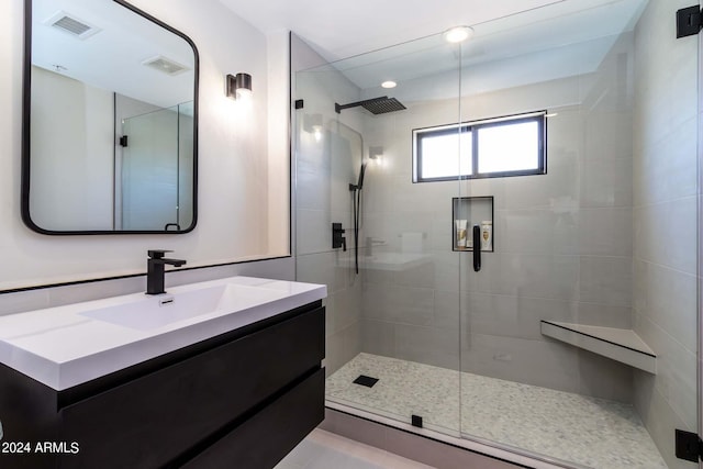 bathroom with vanity with extensive cabinet space and a shower with shower door