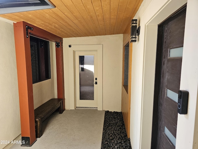 corridor featuring wood ceiling and carpet floors
