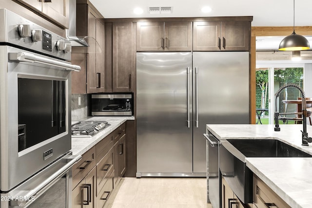 kitchen with decorative backsplash, dark brown cabinets, visible vents, and appliances with stainless steel finishes