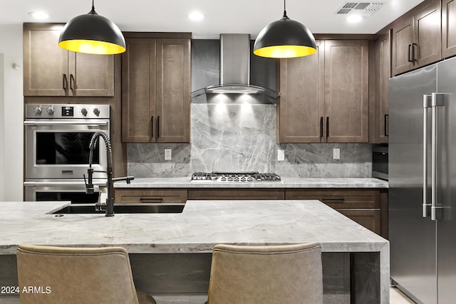 kitchen featuring stainless steel appliances, tasteful backsplash, visible vents, and wall chimney range hood