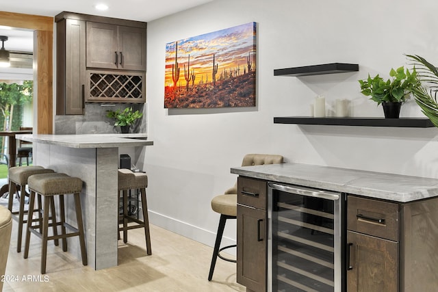 bar featuring tasteful backsplash, baseboards, wine cooler, recessed lighting, and a bar