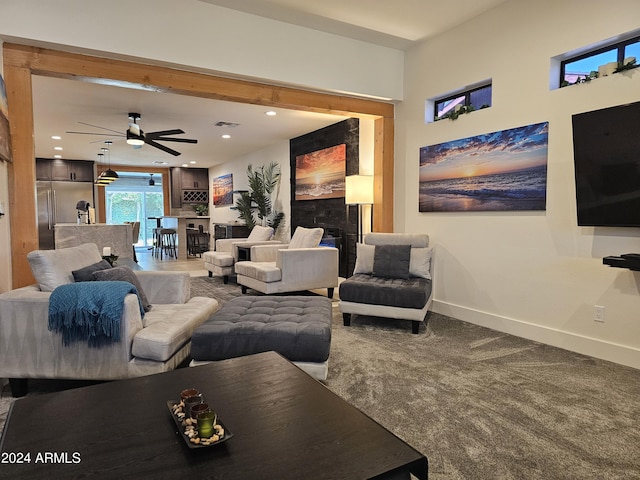 living room featuring visible vents, a ceiling fan, carpet floors, a fireplace, and baseboards