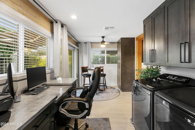 office space with visible vents, a healthy amount of sunlight, a ceiling fan, and washing machine and clothes dryer
