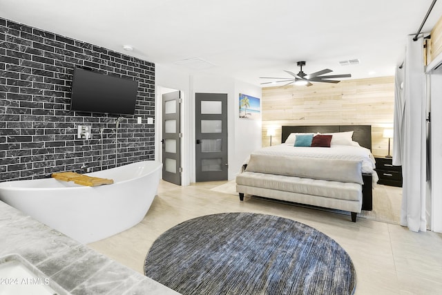 bedroom featuring wooden walls, visible vents, an accent wall, and a ceiling fan