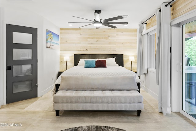 bedroom with access to outside, wooden walls, visible vents, and ceiling fan