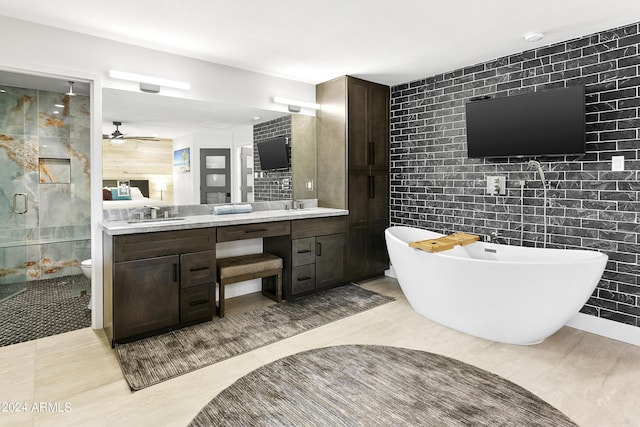 bathroom with a sink, tile walls, a shower stall, double vanity, and ceiling fan