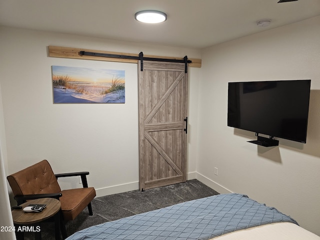 carpeted bedroom with a barn door and baseboards