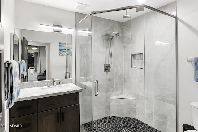 bathroom with visible vents, a shower stall, vanity, and toilet