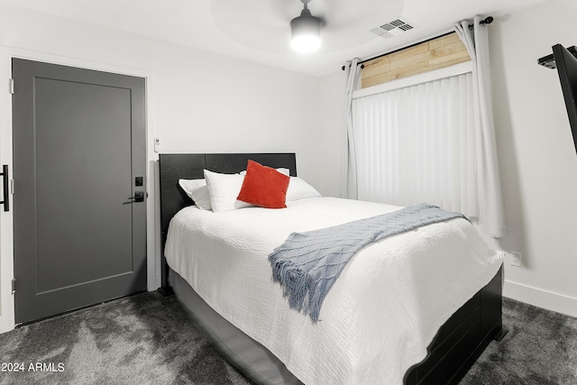 bedroom featuring baseboards, visible vents, dark colored carpet, and ceiling fan