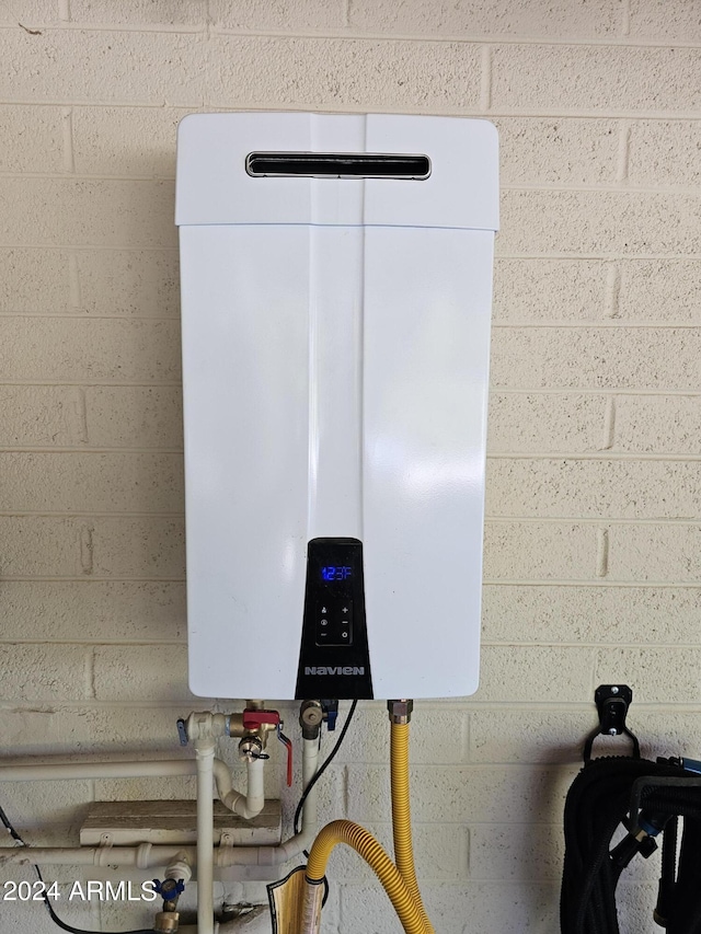 interior details featuring tankless water heater and concrete block wall