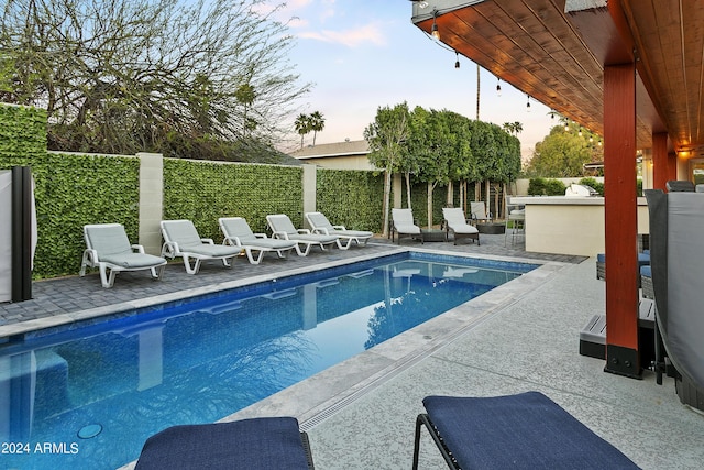 view of swimming pool with a fenced in pool, a patio area, fence, and outdoor dry bar
