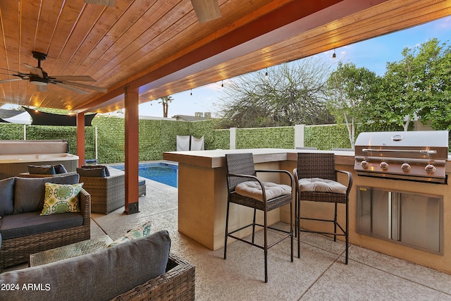 view of patio / terrace featuring a fenced backyard, outdoor wet bar, a grill, outdoor lounge area, and an outdoor kitchen