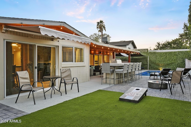 view of patio / terrace featuring outdoor dry bar and an outdoor fire pit
