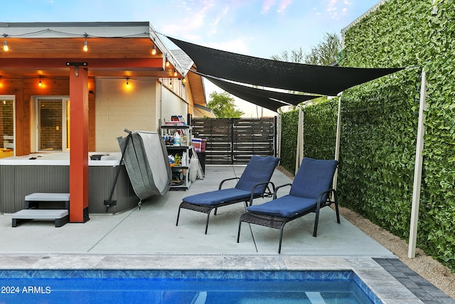 view of patio / terrace with fence, a fenced in pool, and a hot tub