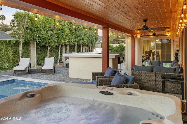 view of patio / terrace featuring an outdoor living space, a hot tub, an outdoor kitchen, and ceiling fan
