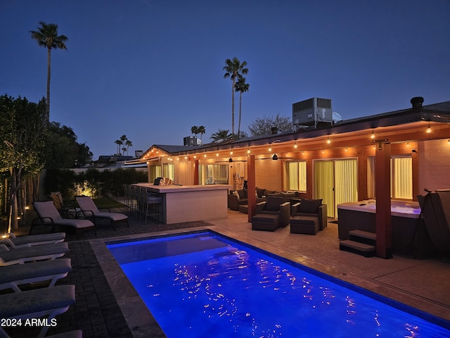 pool at twilight featuring a patio, central AC unit, an outdoor living space, an outdoor pool, and outdoor dry bar