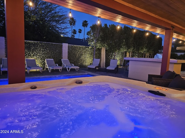 view of pool featuring fence and a hot tub