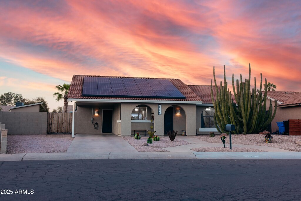 614 W Morrow Dr, Phoenix, AZ 85027 - view of front of home with a tiled roof, stucco siding, fence, and roof mounted solar panels