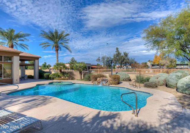 view of pool featuring pool water feature, a hot tub, and a patio