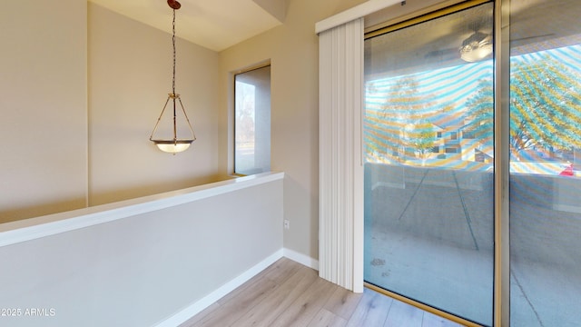 doorway to outside with vaulted ceiling and light hardwood / wood-style floors