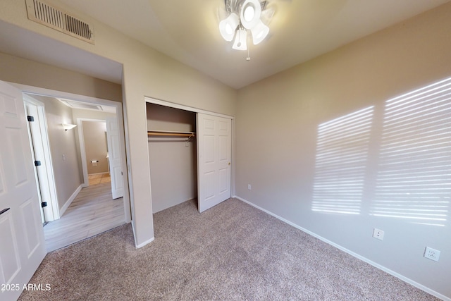 unfurnished bedroom featuring lofted ceiling, light colored carpet, a closet, and ceiling fan