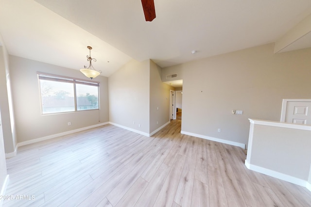 empty room with ceiling fan, lofted ceiling, and light wood-type flooring