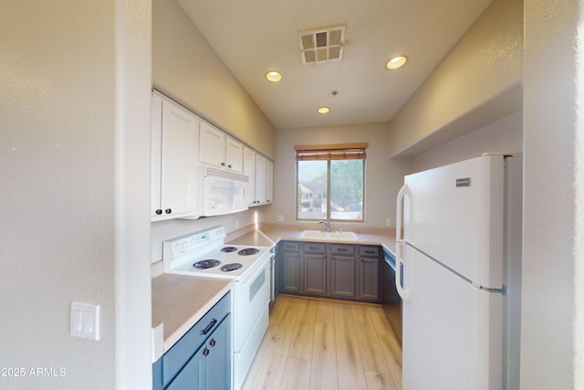 kitchen featuring white cabinetry, sink, gray cabinetry, light wood-type flooring, and white appliances