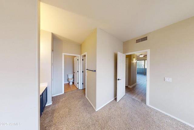 corridor featuring light colored carpet