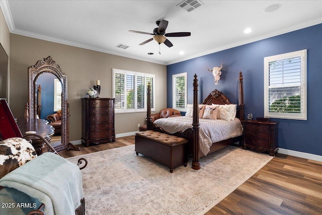 bedroom featuring ornamental molding, visible vents, and wood finished floors