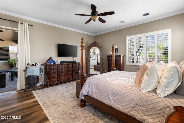 bedroom with arched walkways, ornamental molding, wood finished floors, and visible vents