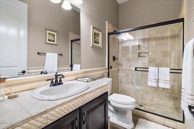 bathroom featuring a stall shower, vanity, and toilet