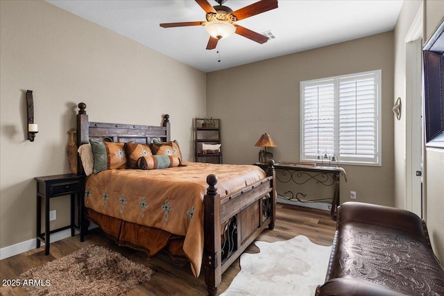 bedroom featuring visible vents, ceiling fan, baseboards, and wood finished floors